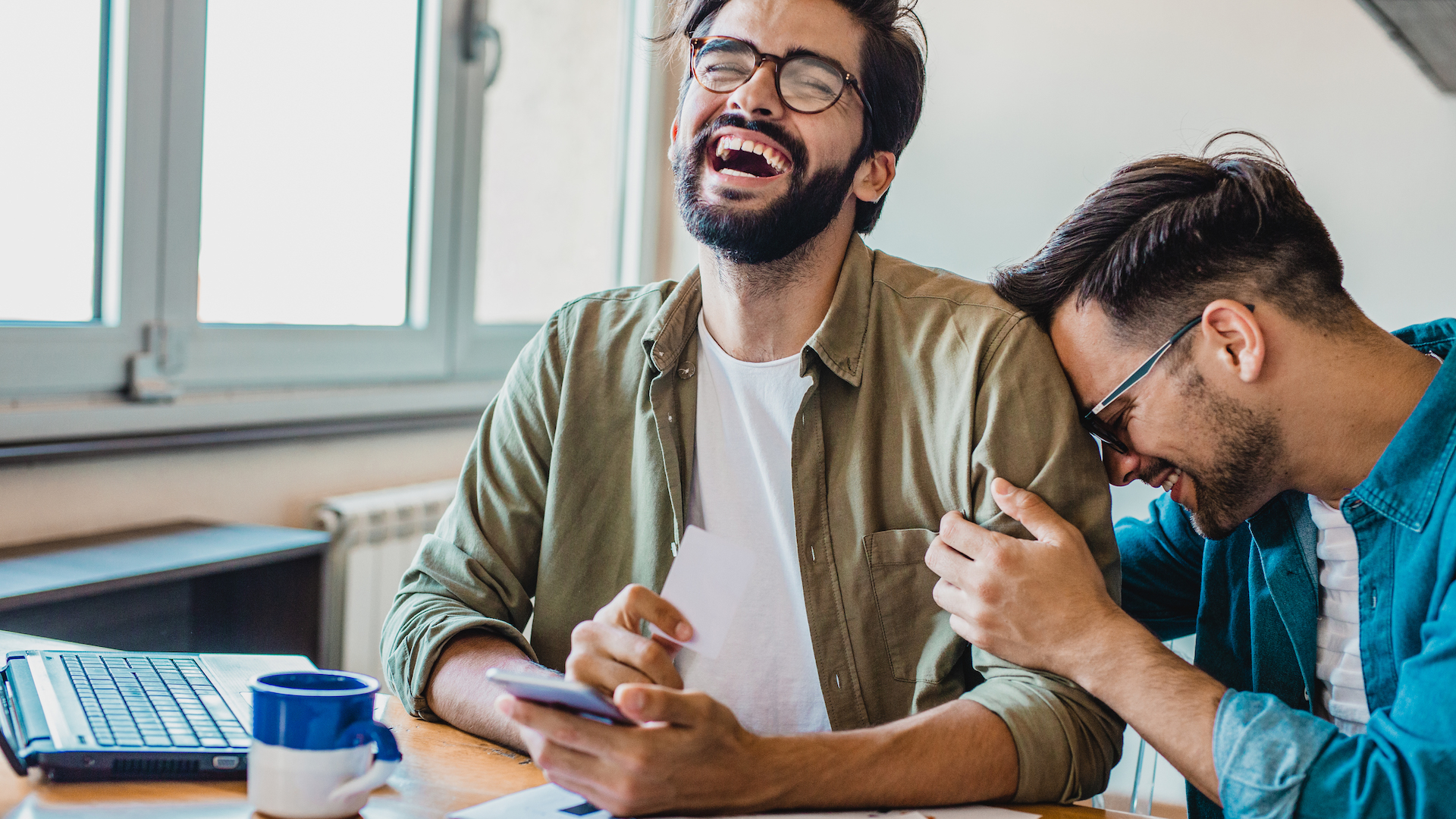 Two young gay freelance workers are at home, they are planning budget.